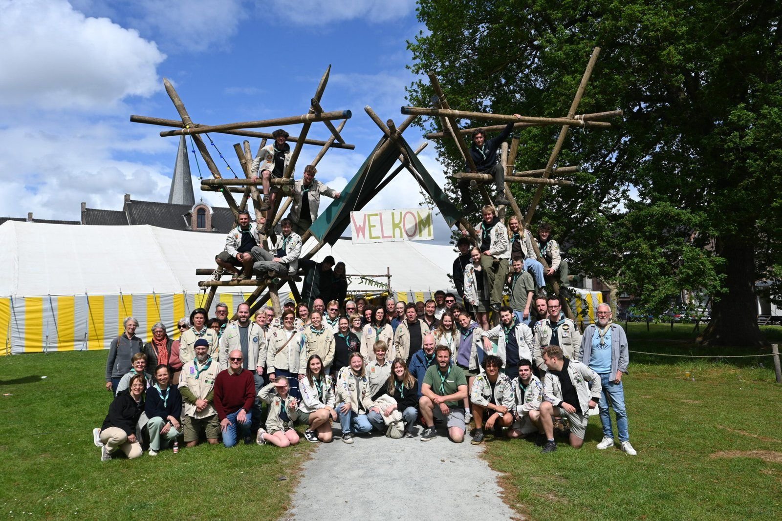 Groepsfoto van Scouts Sinaai bij de kampbouw in den bos